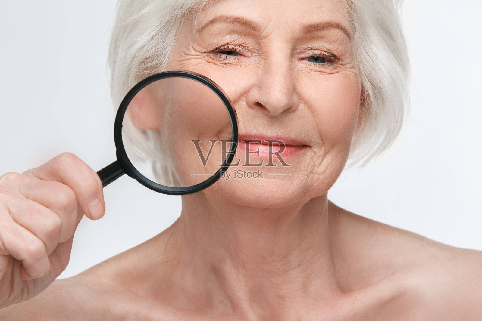 资深女性工作室隔离在白色墙壁上，抱着放大镜的美女概念照片摄影图片