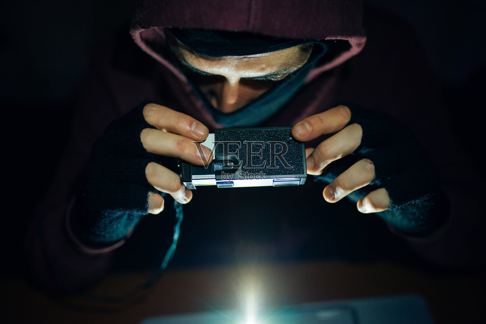 穿连帽衫的男人在收集情报照片摄影图片