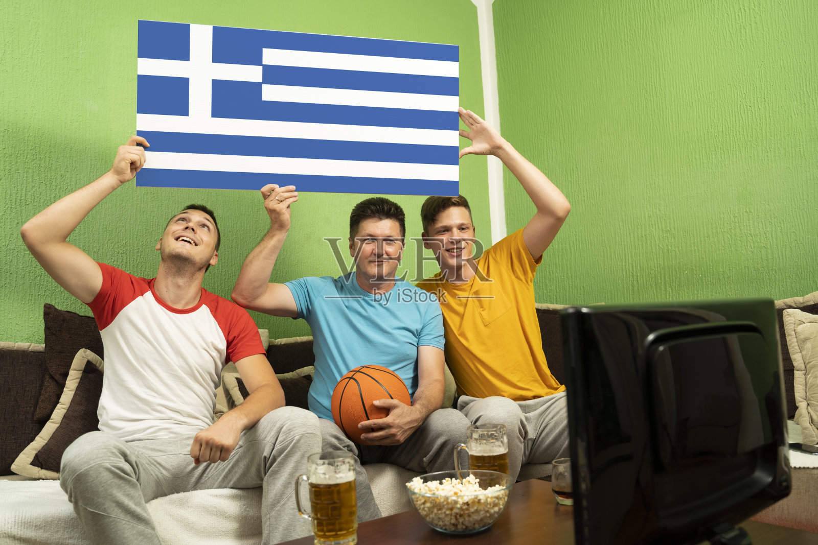 希腊家庭在电视上看篮球比赛照片摄影图片