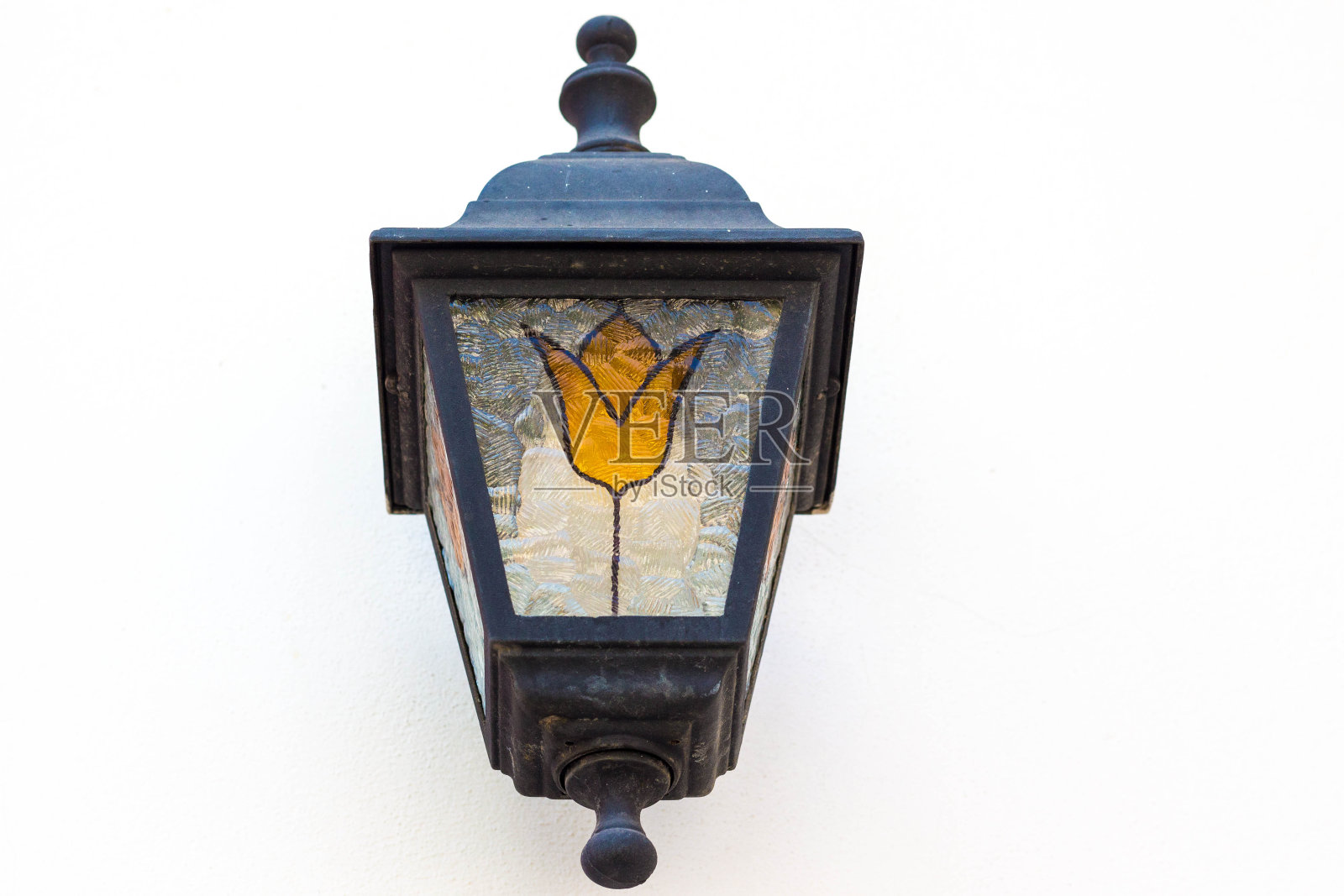 白色的复古灯笼挂在墙上。一盏金属灯上画着一朵黄色的花。照片摄影图片