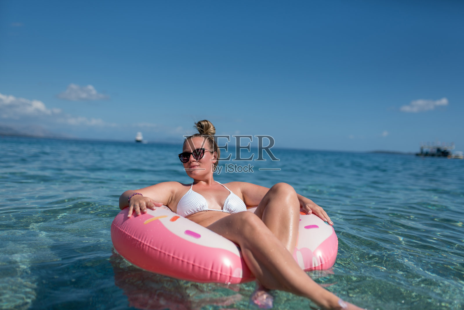 漂亮的年轻女子与粉红色的甜甜圈照片摄影图片