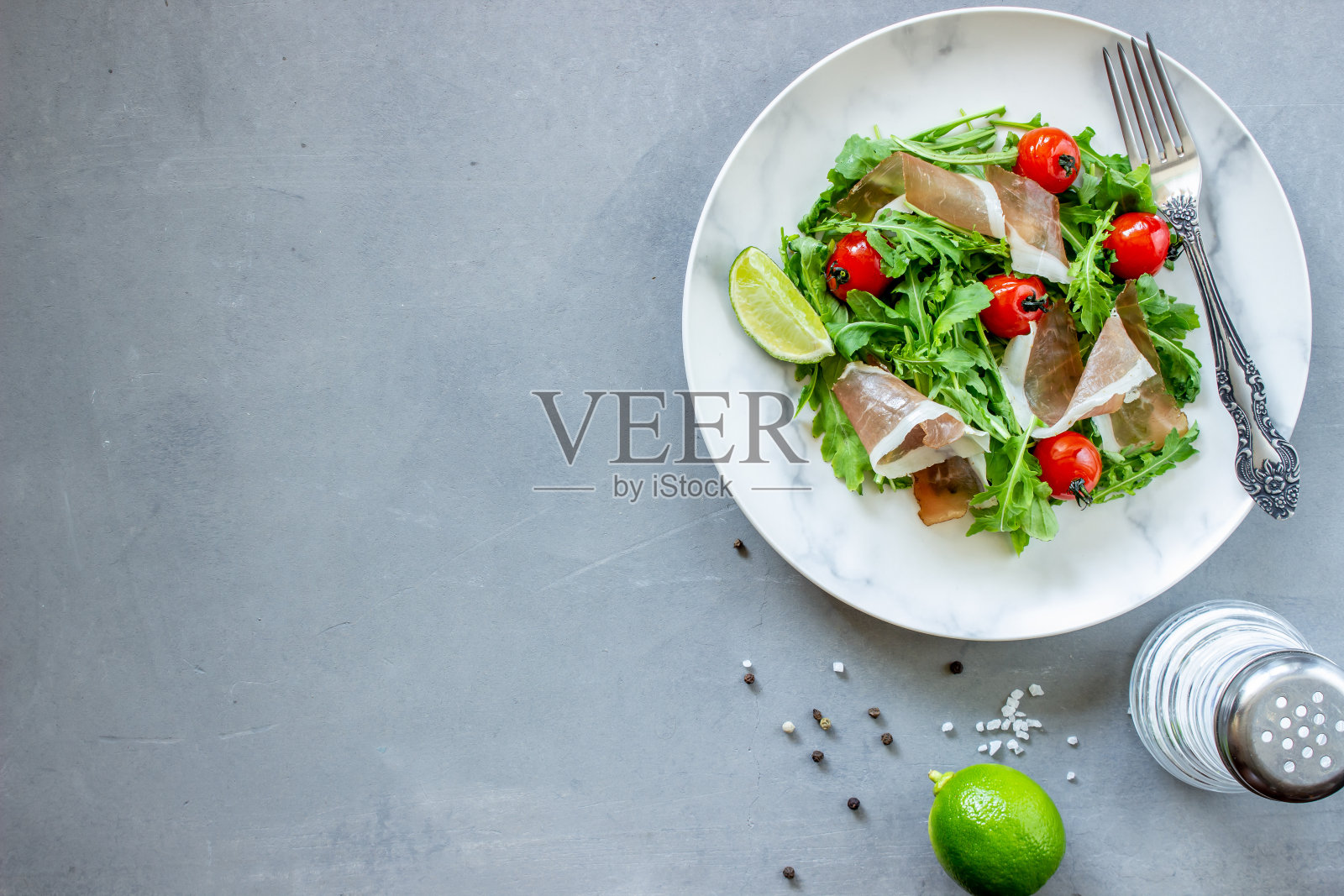 芝麻菜、番茄和意大利熏火腿的沙拉。意大利菜。健康饮食。饮食。照片摄影图片