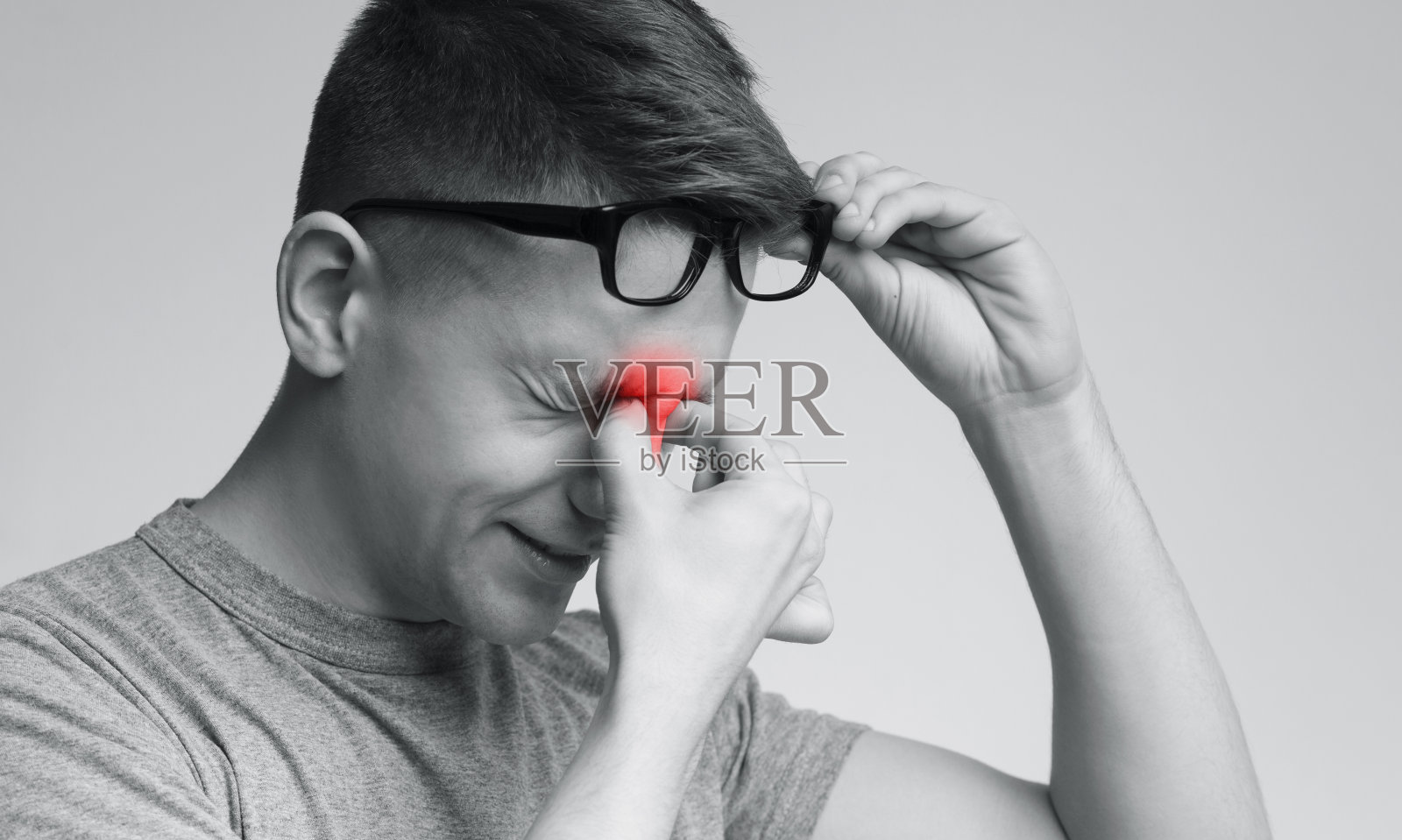 摘下眼镜的疲惫年轻男人照片摄影图片