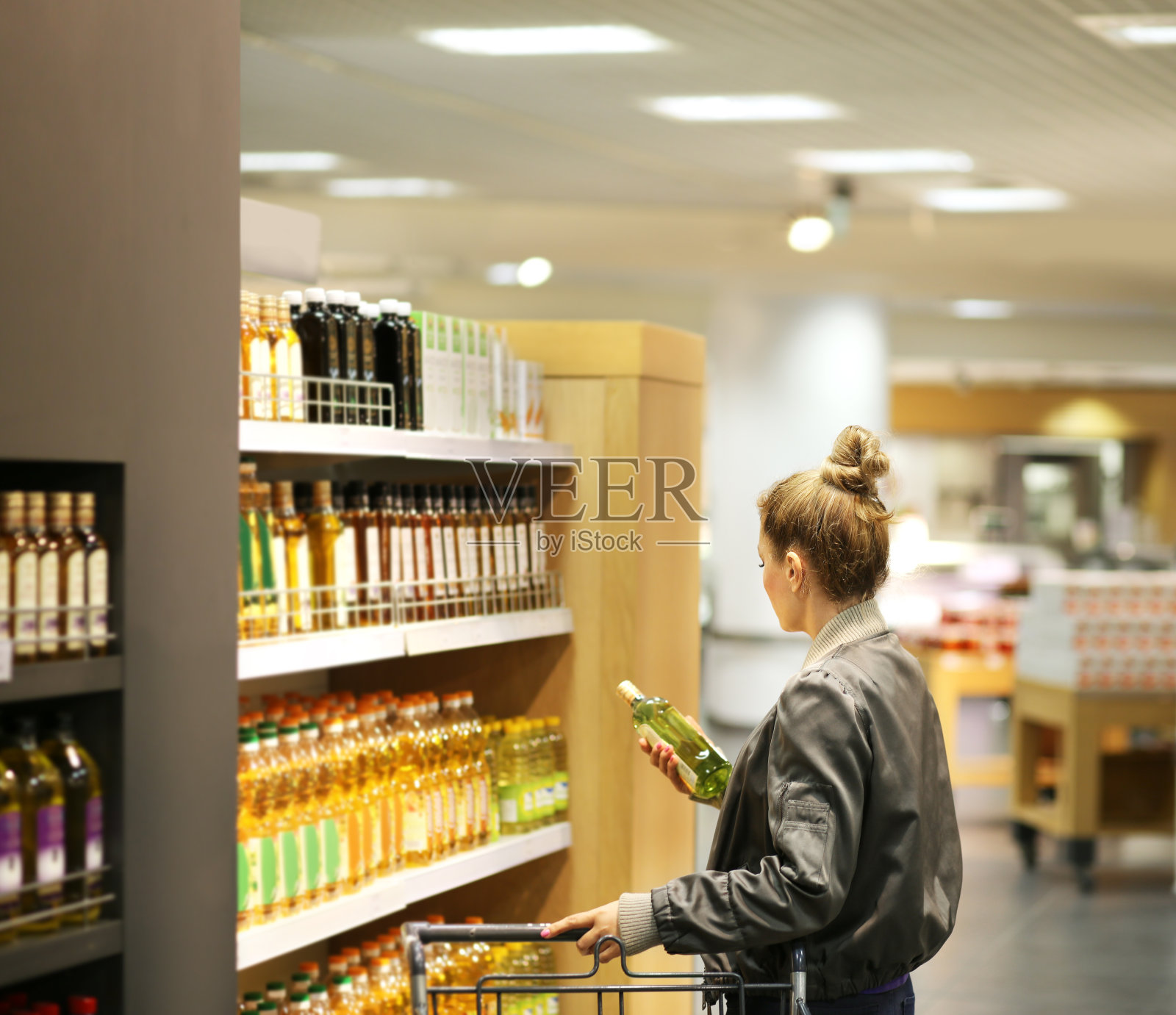 女人在超市购物阅读产品信息。照片摄影图片