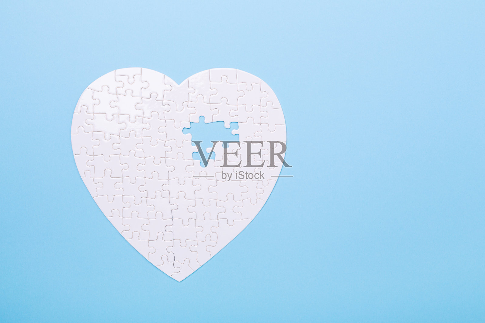 白色拼图在蓝色背景上的心形拼图概念治疗心脏病的药丸照片摄影图片