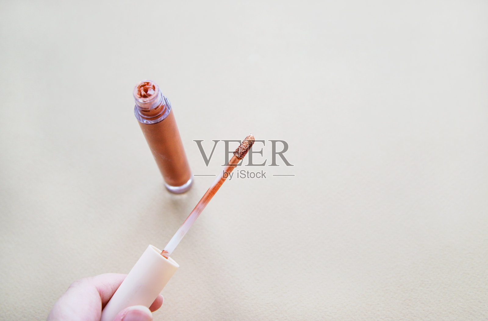 手上有青铜色的唇彩。秋季美妆概念照片摄影图片