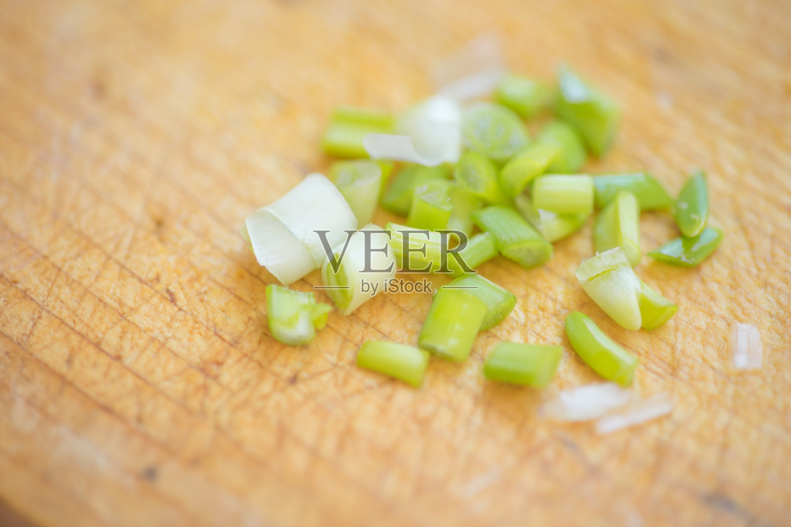 在棕色的木板上切葱。照片摄影图片