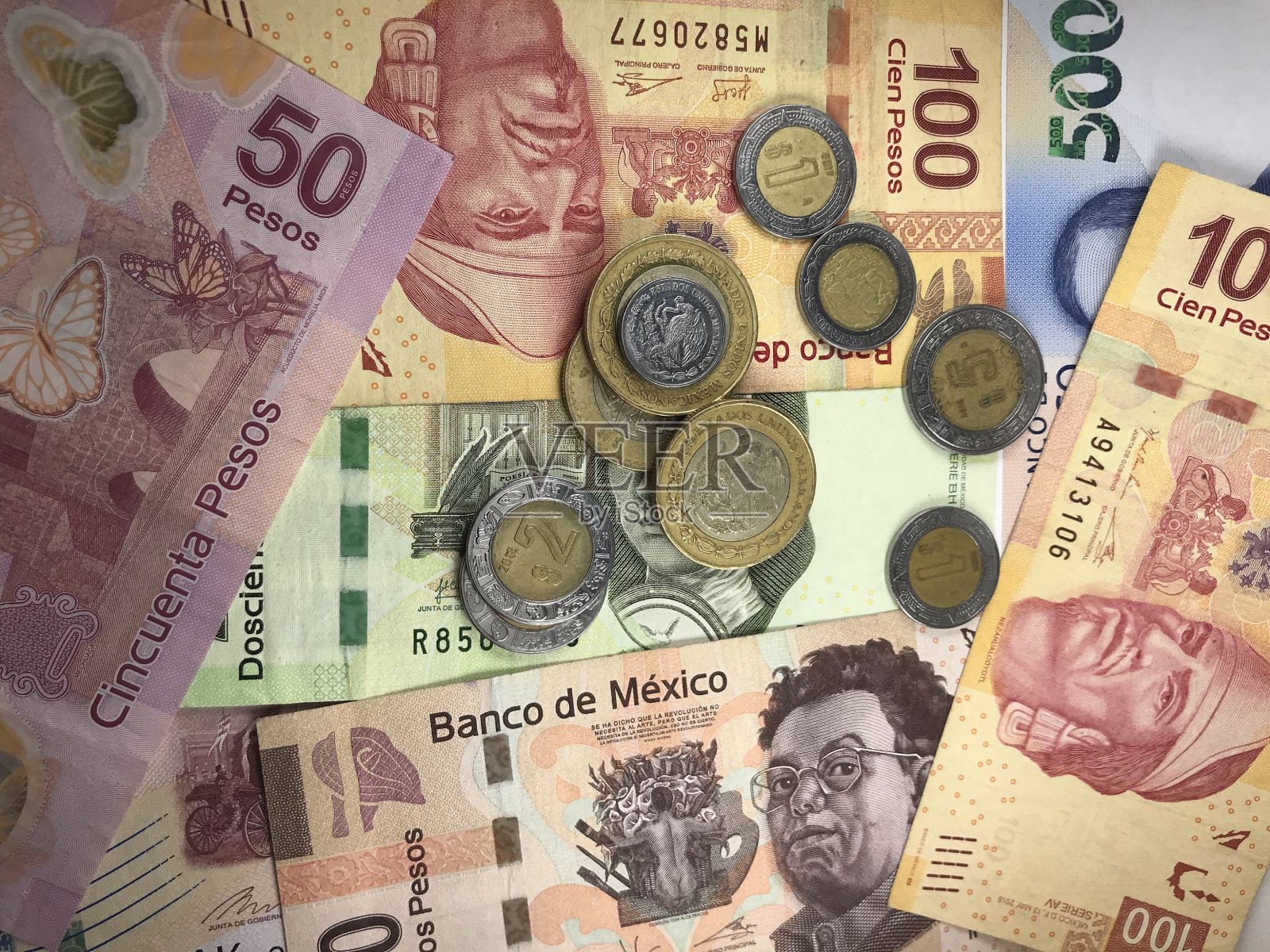 许多墨西哥比索纸币随机地散布在一个平面上照片摄影图片