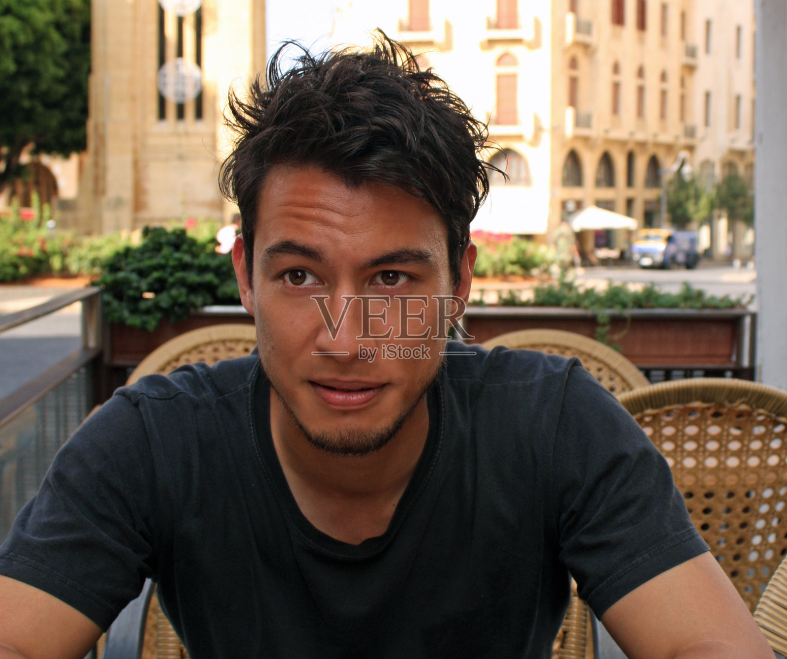 在咖啡馆里有着狂野黑发的年轻男人照片摄影图片