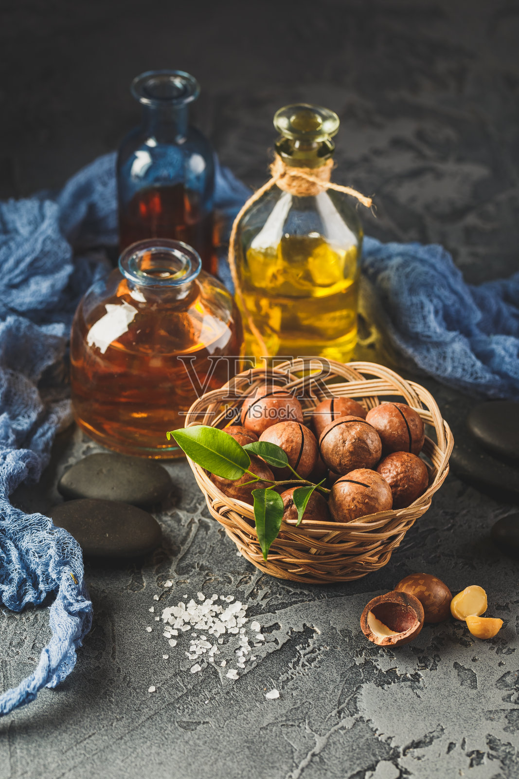 天然澳洲坚果油在玻璃瓶与澳洲坚果照片摄影图片