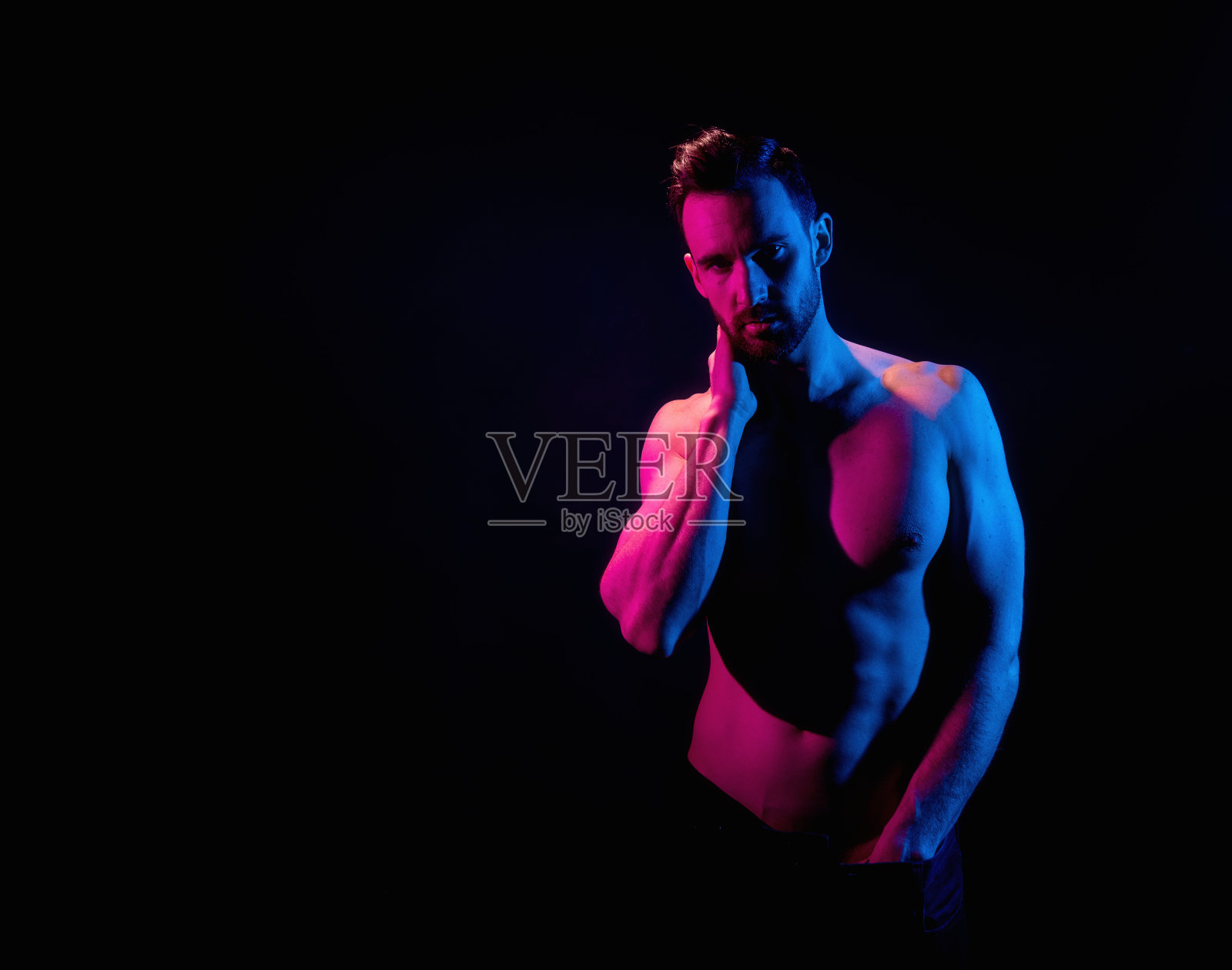 英俊的男子在黑色背景与红色和蓝色照明照片摄影图片