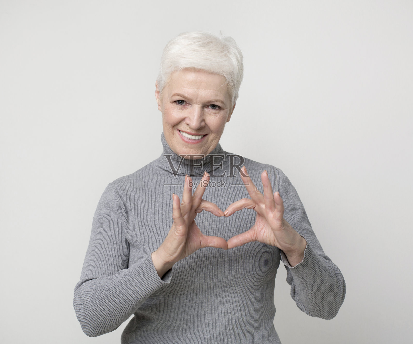 迷人的老年妇女显示心的姿态和微笑照片摄影图片