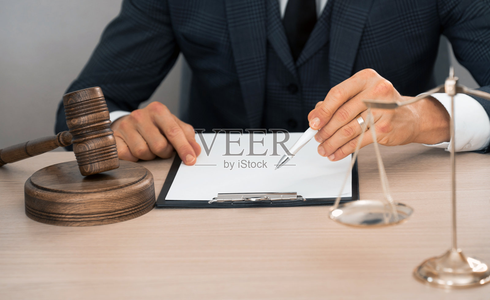 法律与法律服务概念：律师或法官在法庭的桌子上处理合同文件、法律书籍和木槌照片摄影图片