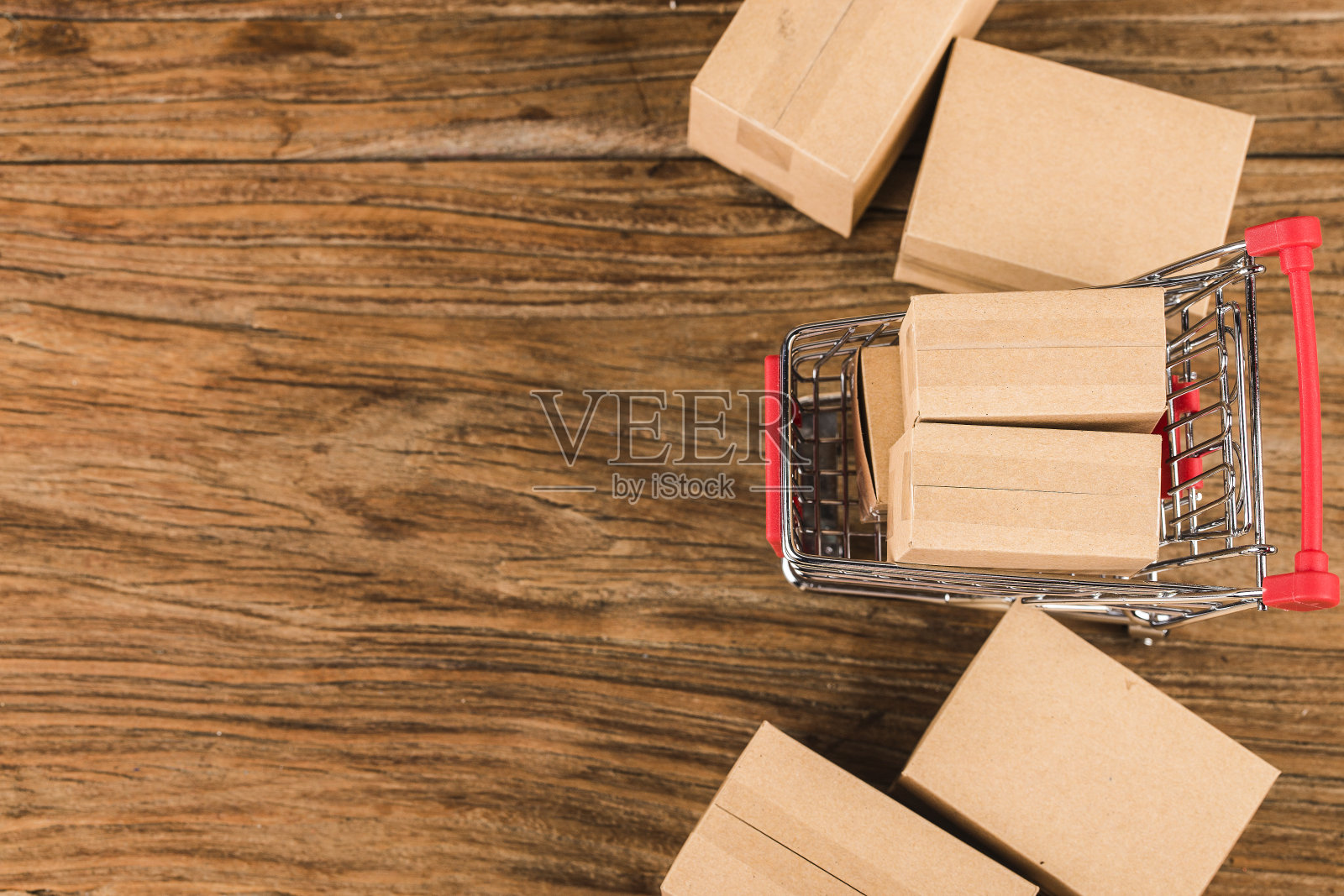 在家网上购物的概念。购物车里的纸箱放在笔记本电脑键盘上。网上购物是一种电子商务形式，它允许消费者通过互联网直接从卖家那里购买商品照片摄影图片