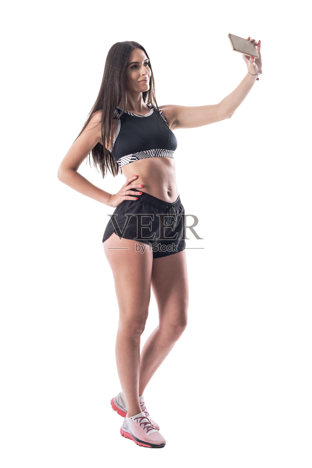 快乐自信的年轻健身女运动员用智能手机自拍社交媒体。照片摄影图片