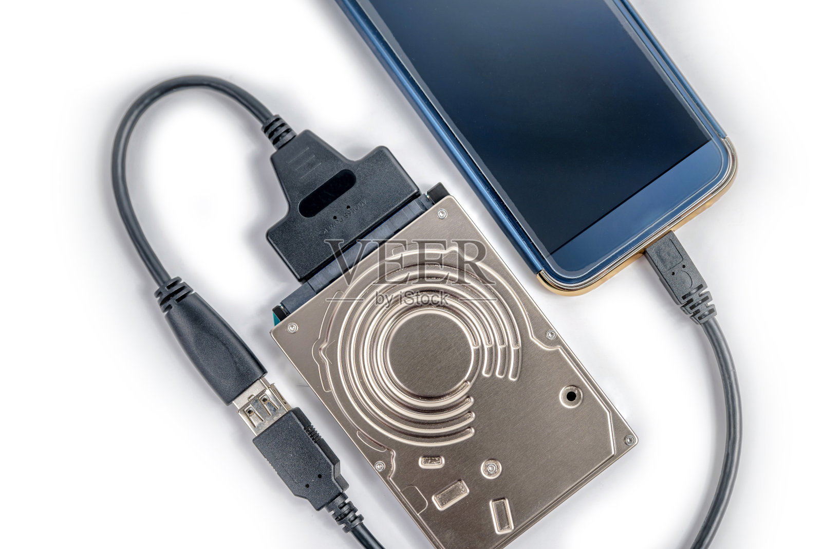 HDD 2.5硬盘通过sata usb电缆连接到智能手机的特写俯视图照片摄影图片