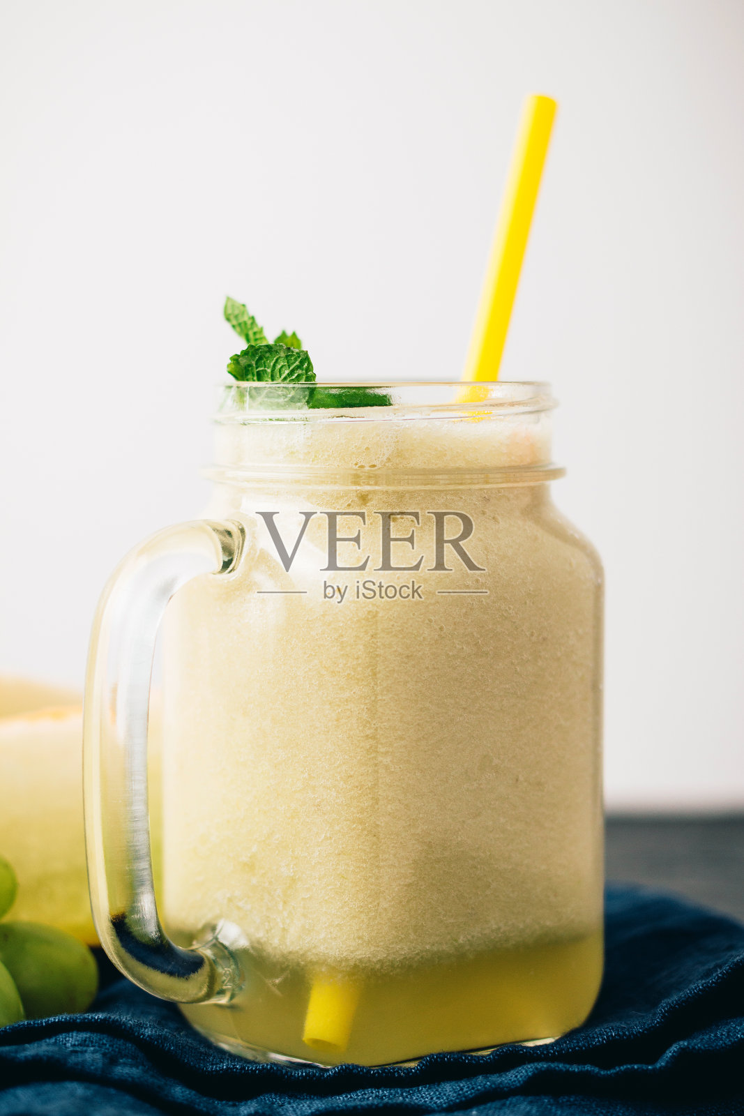 甜瓜冰沙在一个罐子与新鲜薄荷叶和葡萄照片摄影图片