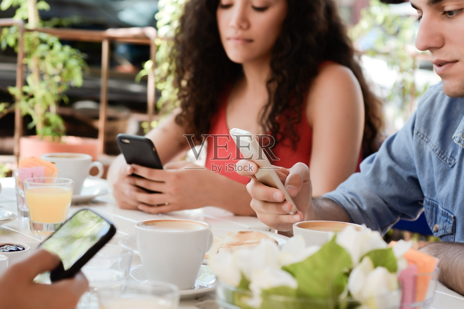 朋友在咖啡店用智能手机。照片摄影图片