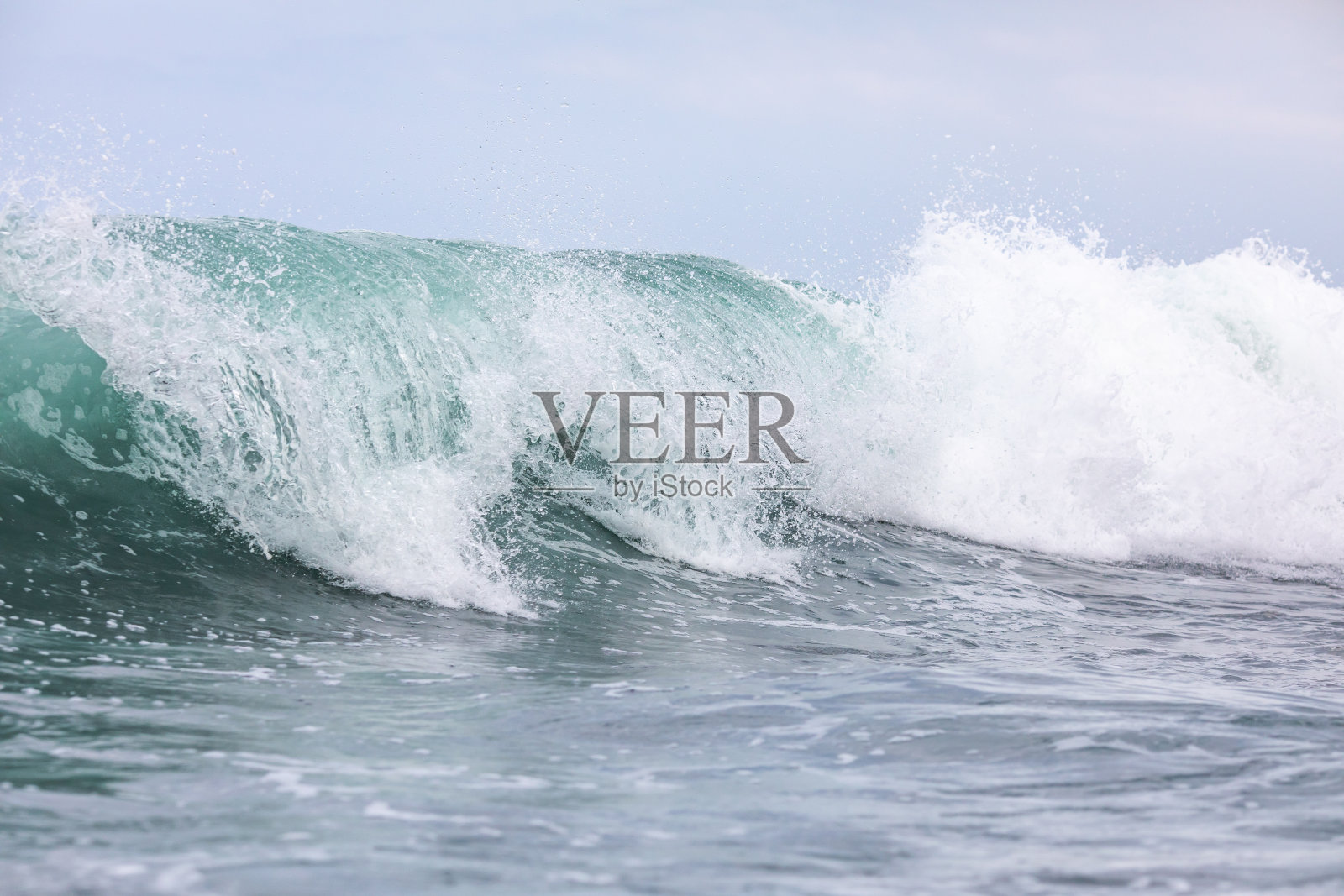 大海中蓝色的波浪。在巴厘岛破浪冲浪照片摄影图片