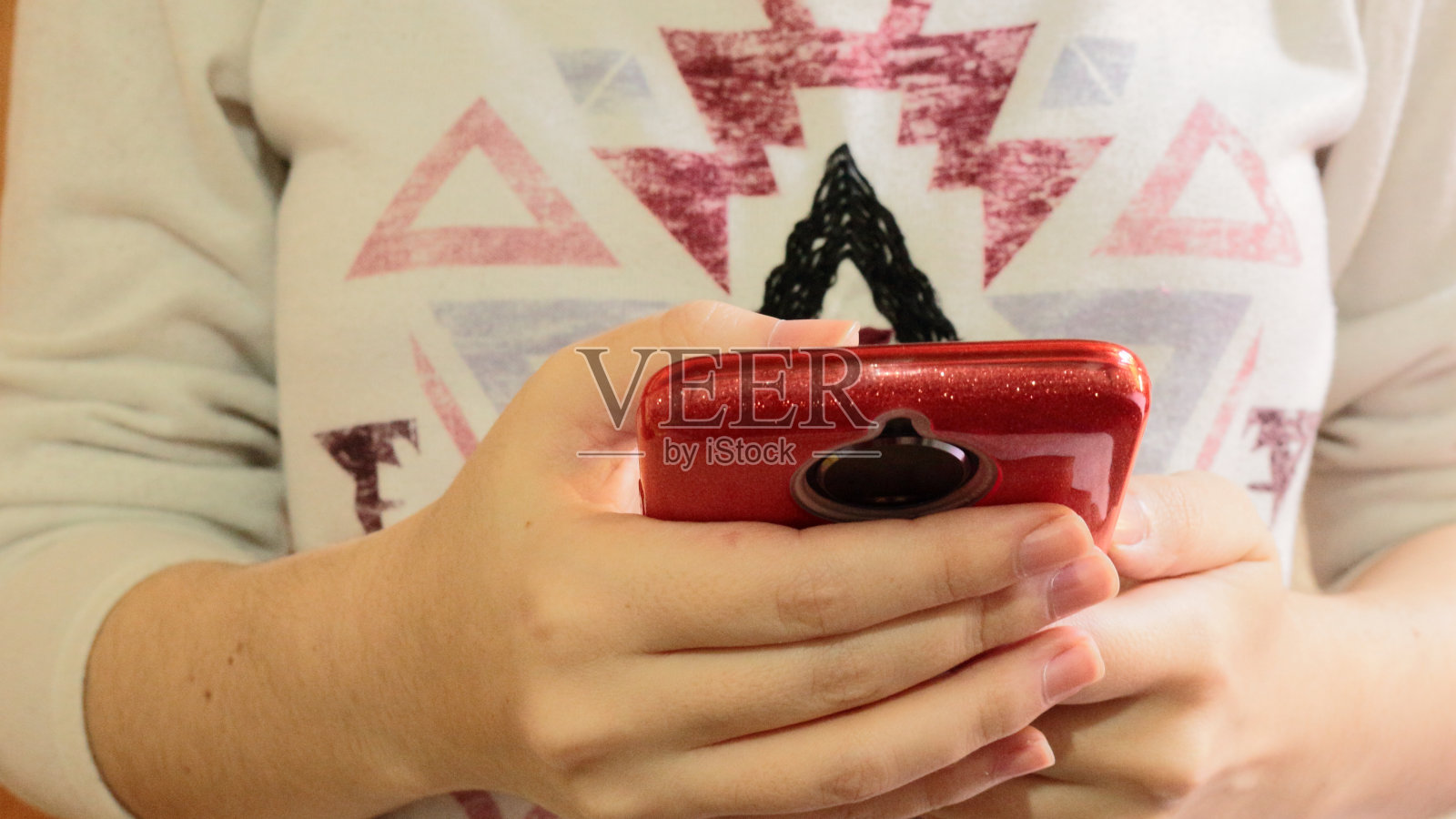 女孩拿着你的手机上网。一直把设备放在手上是一种习惯。手机有硅胶保护套保护照片摄影图片