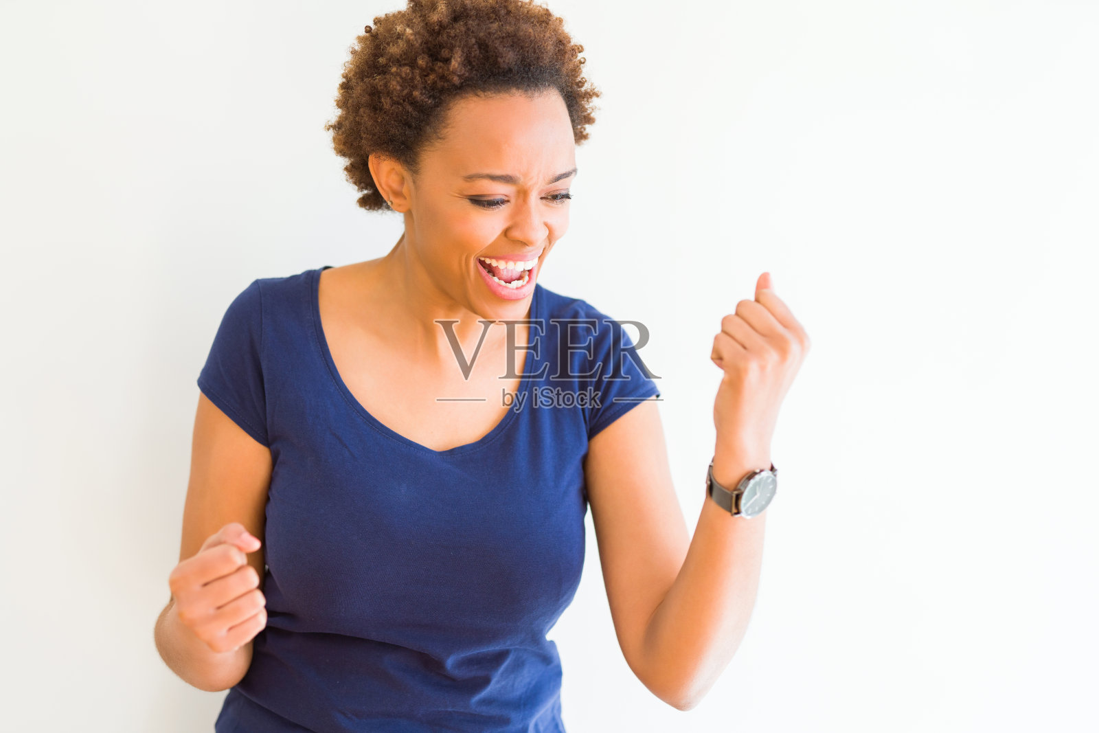 年轻美丽的非洲裔美国妇女在白人背景非常高兴和兴奋做胜利者的姿态，举起手臂，微笑和尖叫为成功。庆祝活动的概念。照片摄影图片