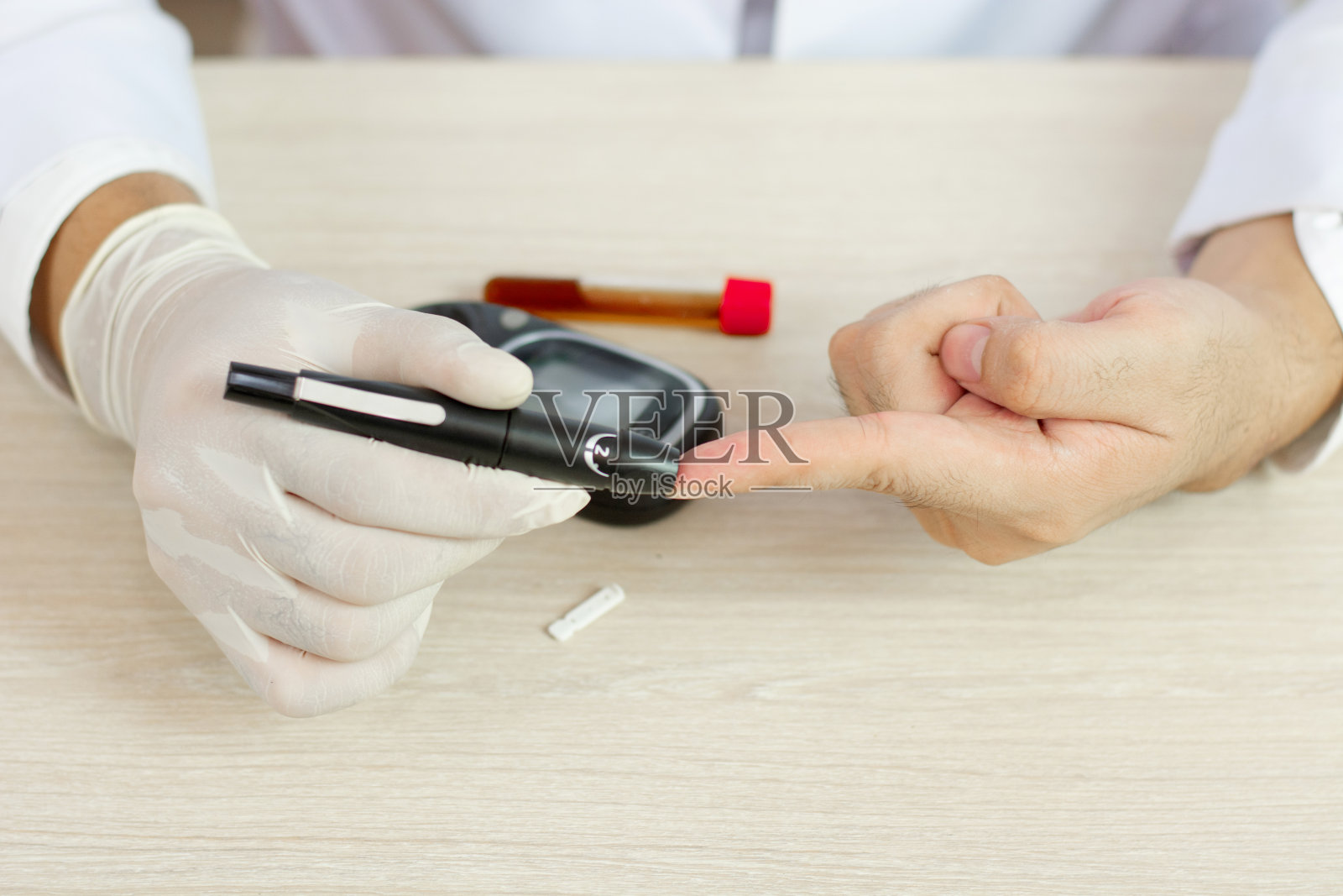 男人用柳叶刀在手指上检查血糖照片摄影图片