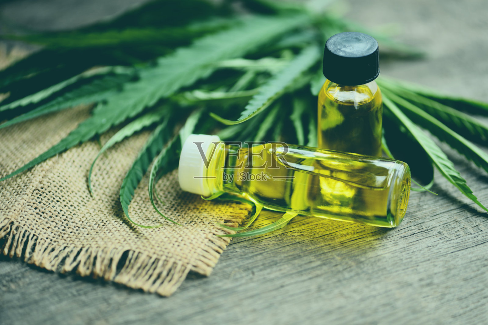 大麻油瓶产品木质背景-大麻二酚油提取自大麻叶大麻叶医疗保健天然大麻照片摄影图片