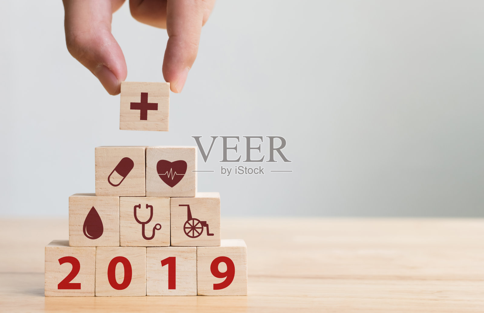 手排列木块堆叠与图标医疗保健，保险为您的健康在2019年的概念照片摄影图片