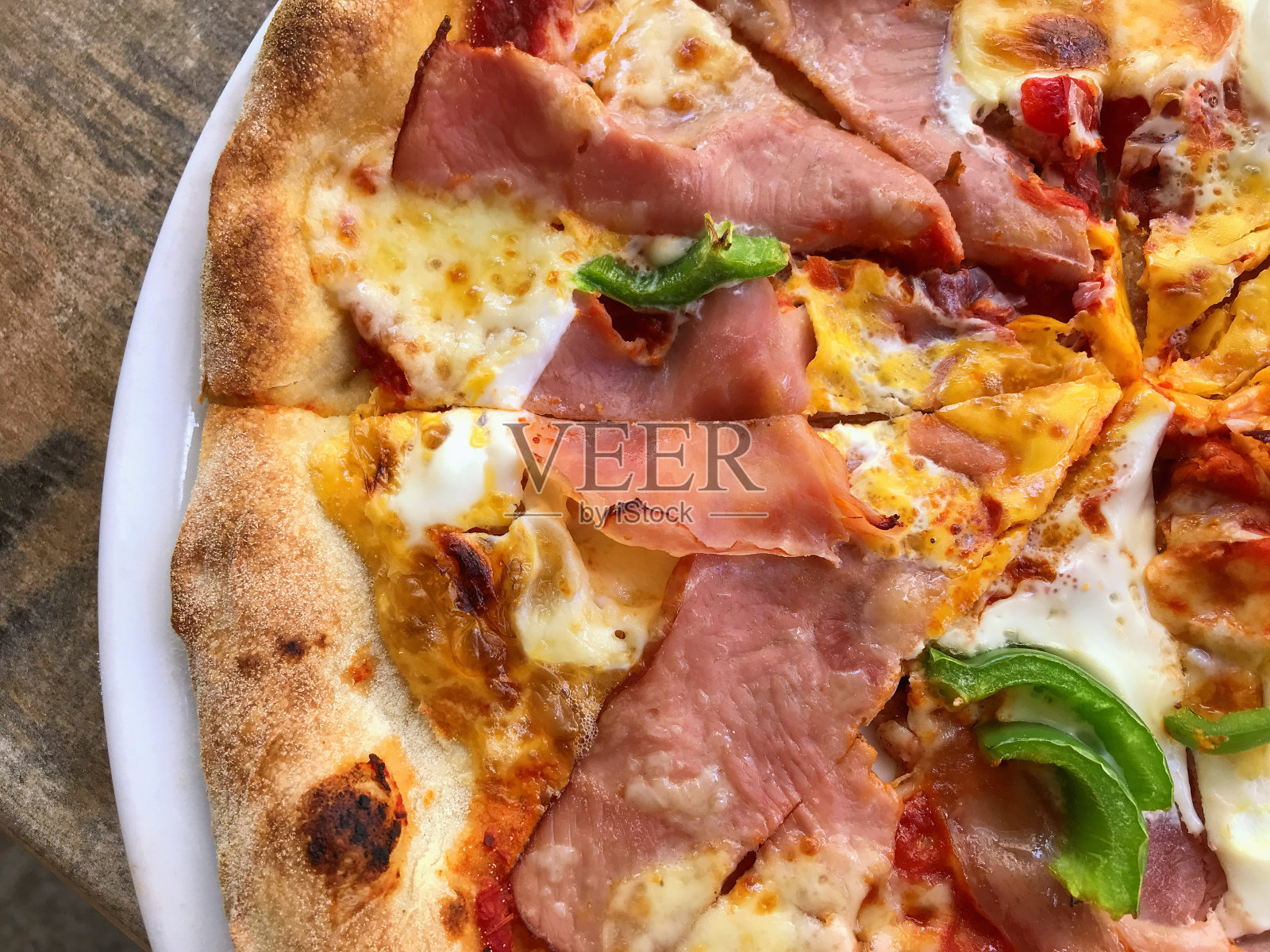 有火腿，培根，西红柿，洋葱蛋和胡椒的比萨照片摄影图片