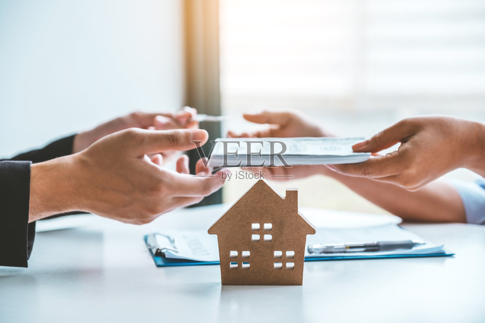 女客户签订购房协议，业务员签好贷款合同后收钱。照片摄影图片