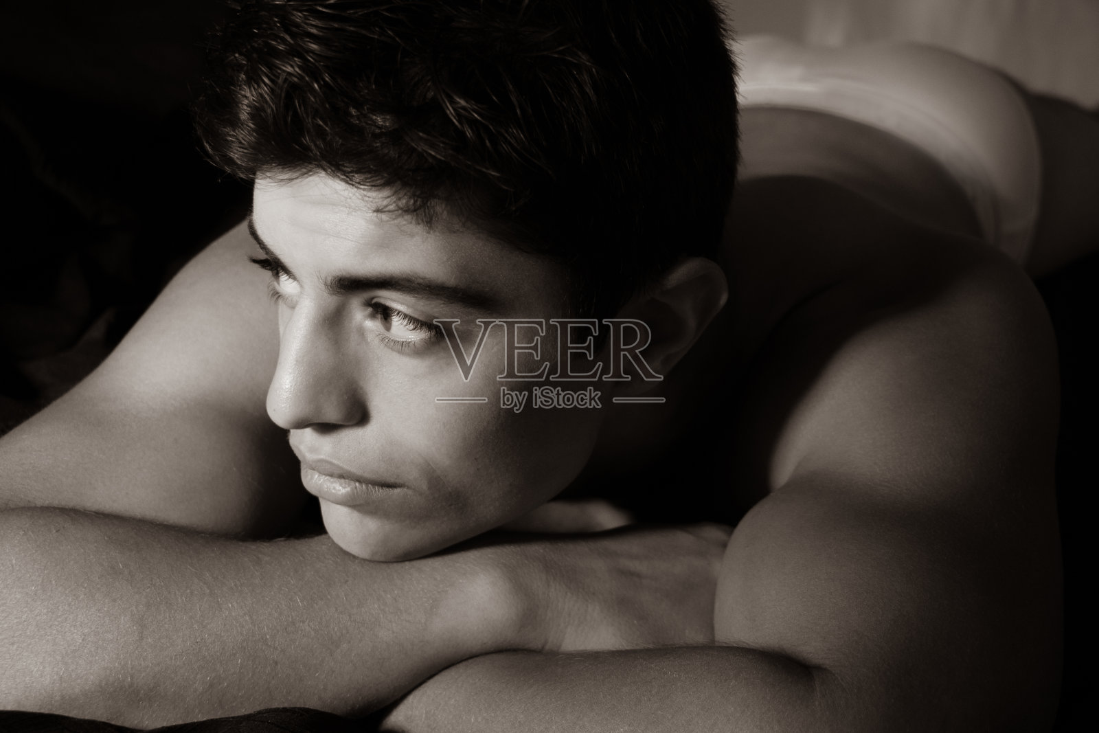 英俊，肌肉发达的拉丁人在他的内裤躺在床上照片摄影图片