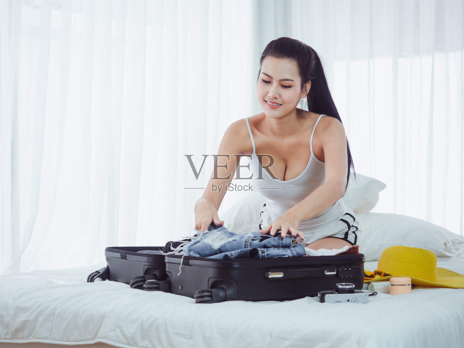 美丽的女人正在准备去度假的包照片摄影图片