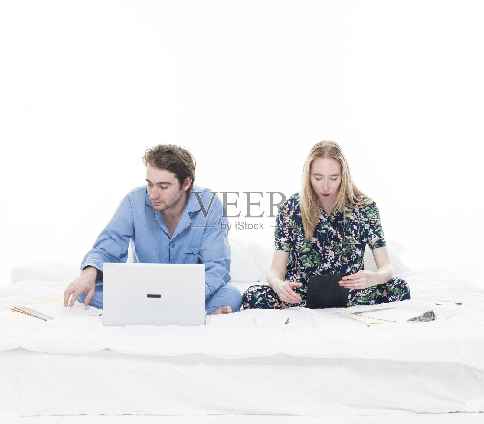 两个人坐在床上工作照片摄影图片