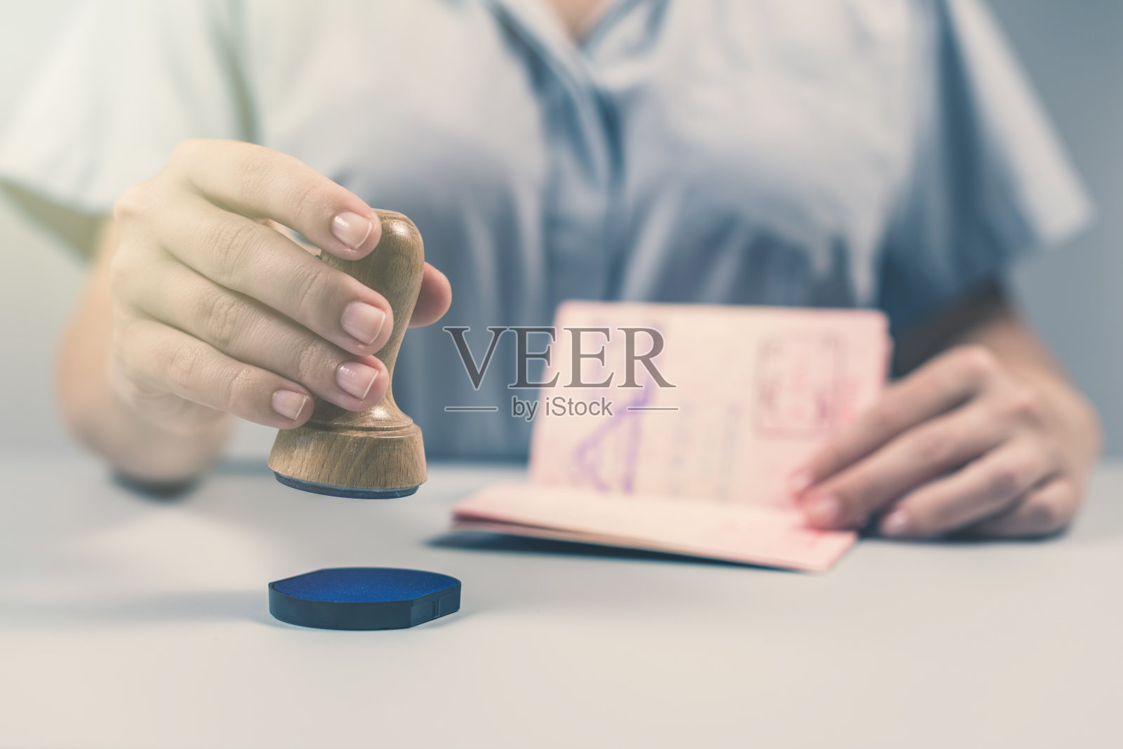 机场的出入境和护照检查。一名女边防官员在护照上盖了章。概念照片摄影图片