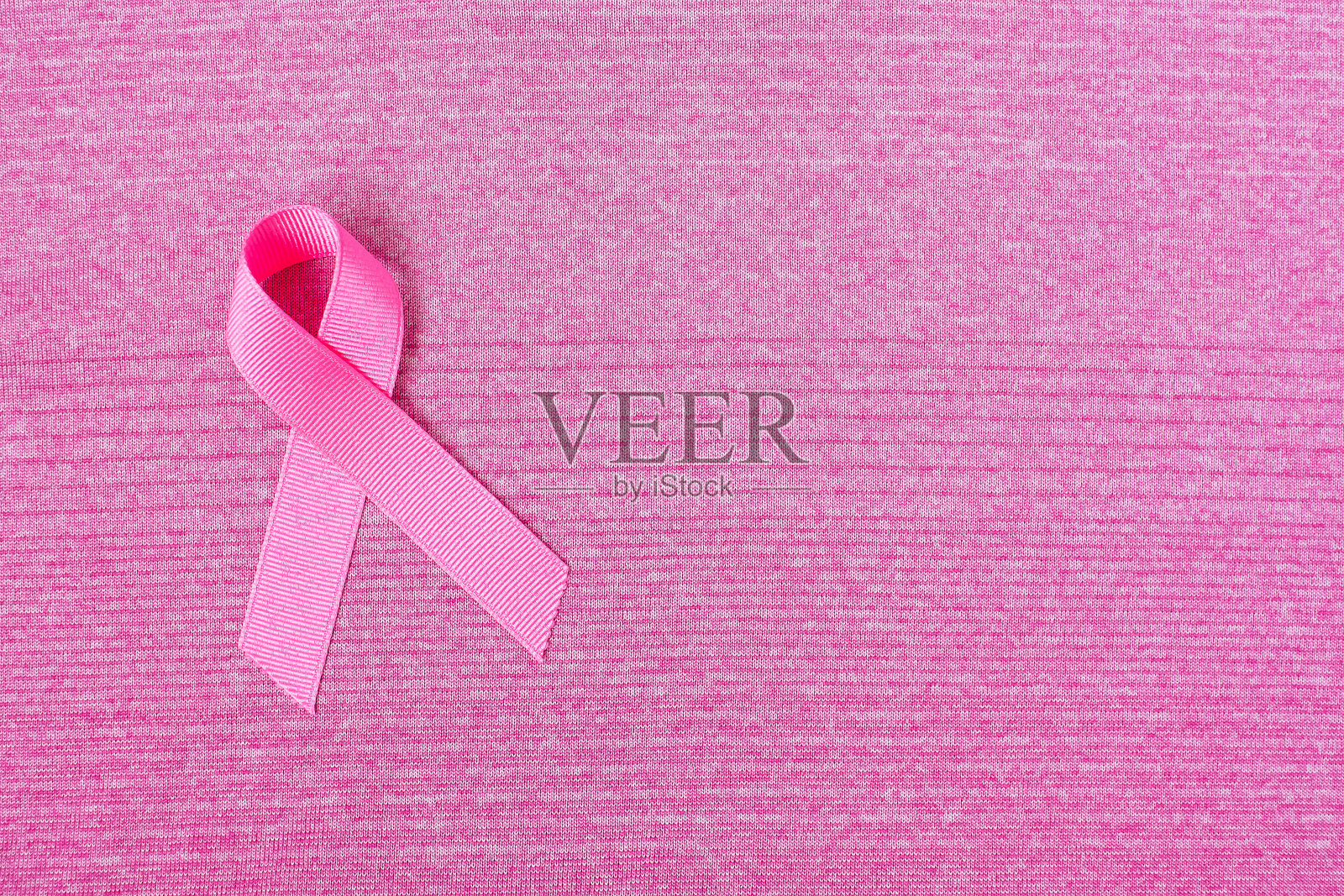 10月乳腺癌宣传月，粉红色衬衫上的粉红丝带，以支持人们的生活和疾病。保健、国际妇女节和世界癌症日的概念照片摄影图片