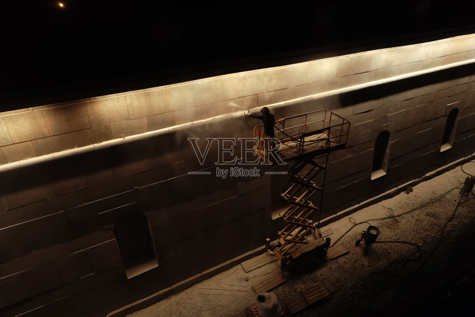 工人用喷枪在墙上喷漆照片摄影图片