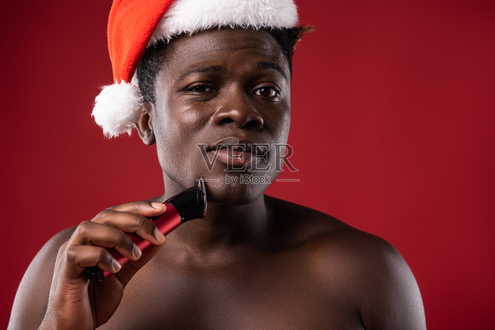 裸男正在刮胡子，看着镜头照片摄影图片