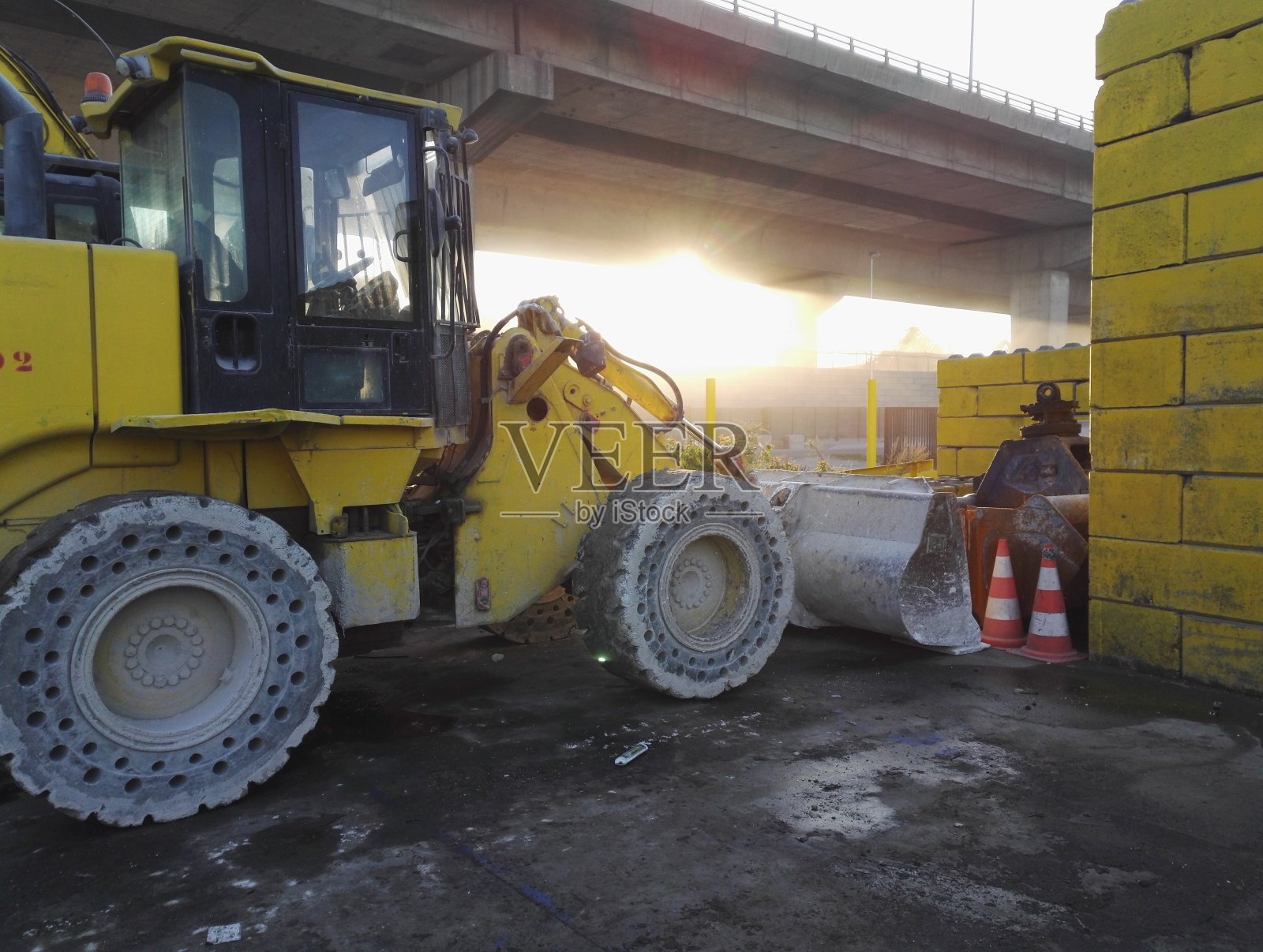 黎明时分，黄色拖拉机和铁铲停在一个工业垃圾场照片摄影图片