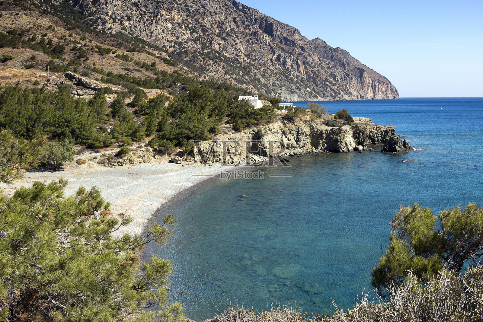 瓦南达湾，卵石滩和清澈的大海，上面的两个白色小教堂-卡尔帕索斯岛，爱琴海照片摄影图片