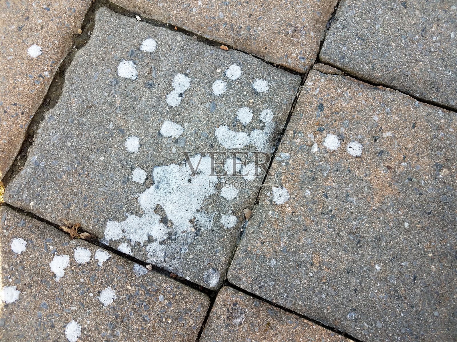 白色的冰淇淋滴在灰色的石头瓷砖上照片摄影图片