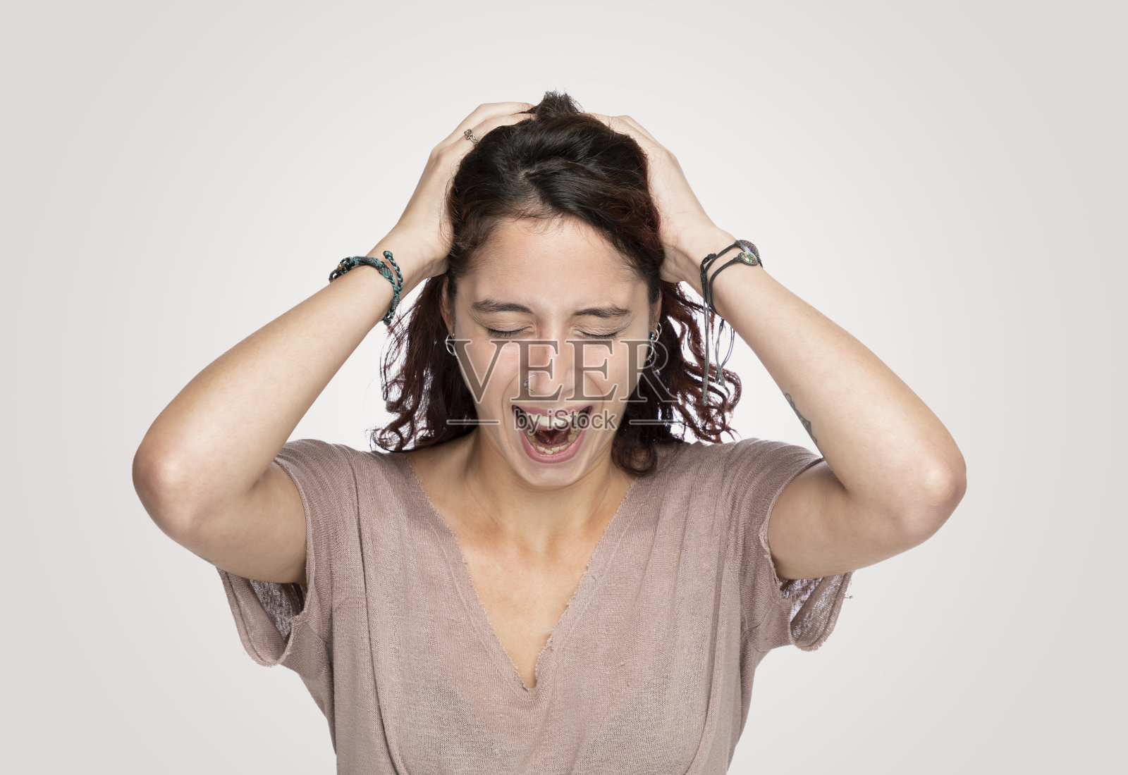 在灰色背景上抓头的沮丧女人照片摄影图片