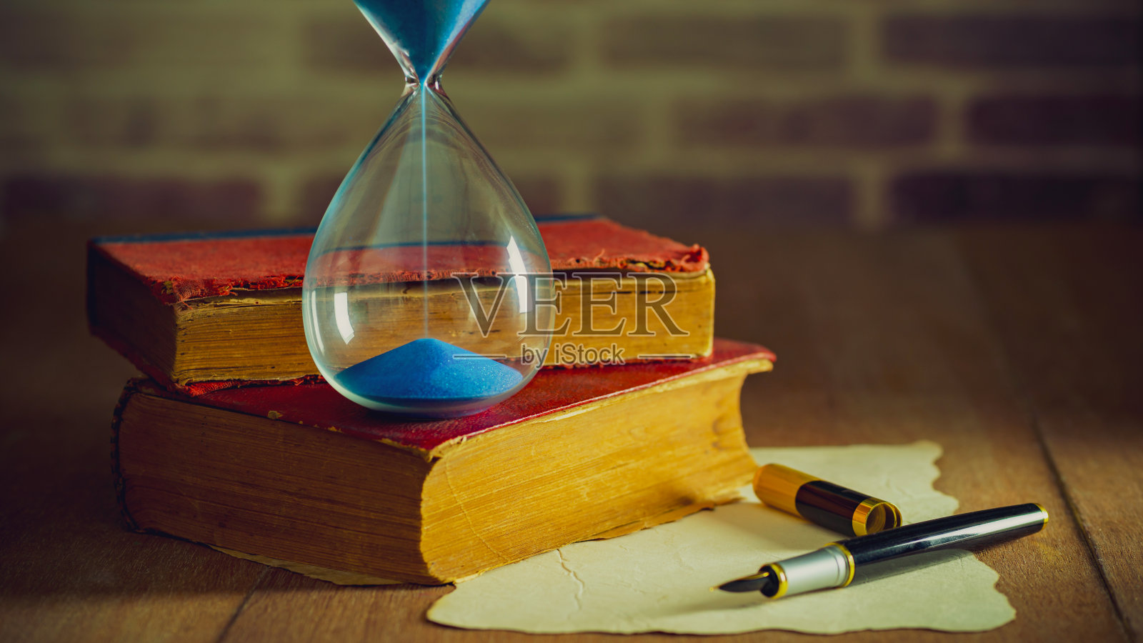 沙钟和旧书。照片摄影图片