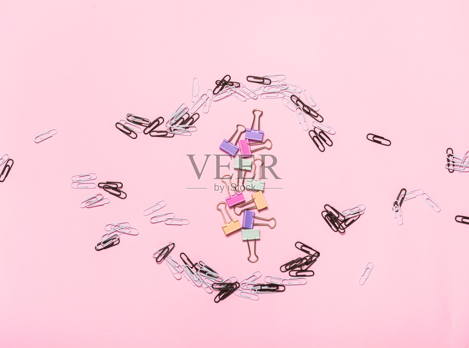 不同明亮的回形针图案在粉红色的背景。照片摄影图片