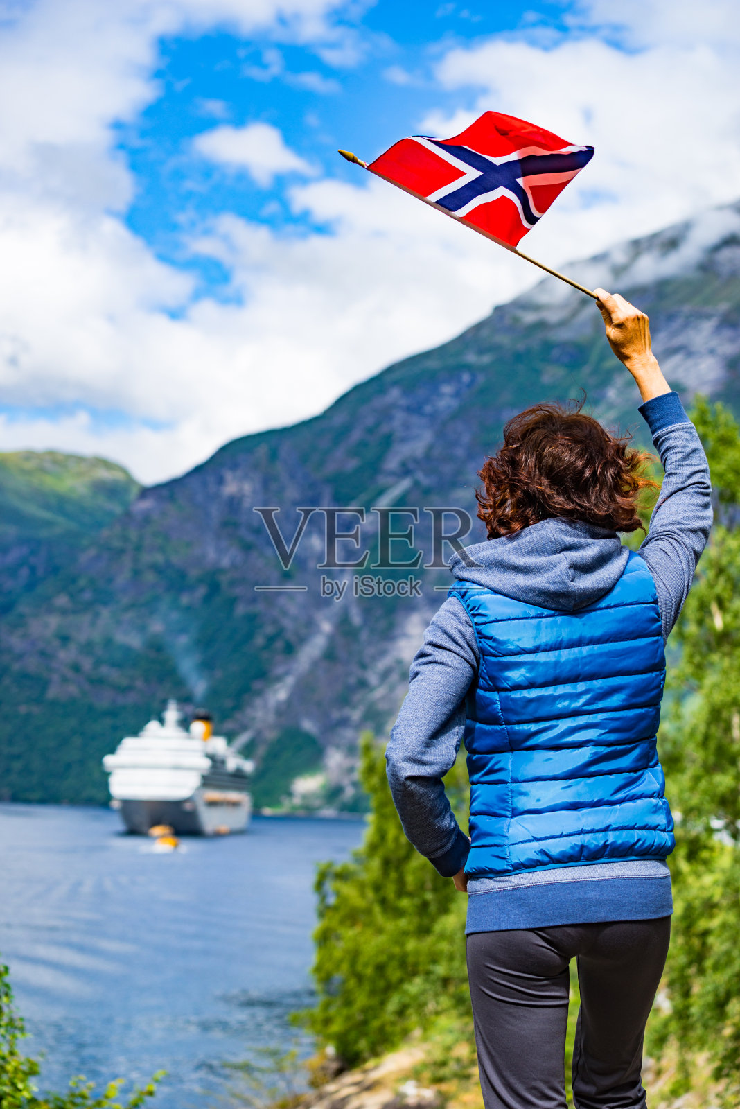 游客拿着挪威国旗和渡轮在峡湾照片摄影图片