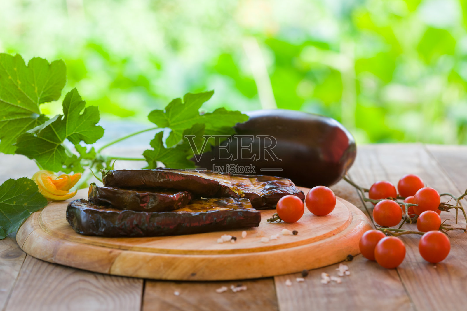 烤茄子片，配樱桃番茄，放在木板上照片摄影图片