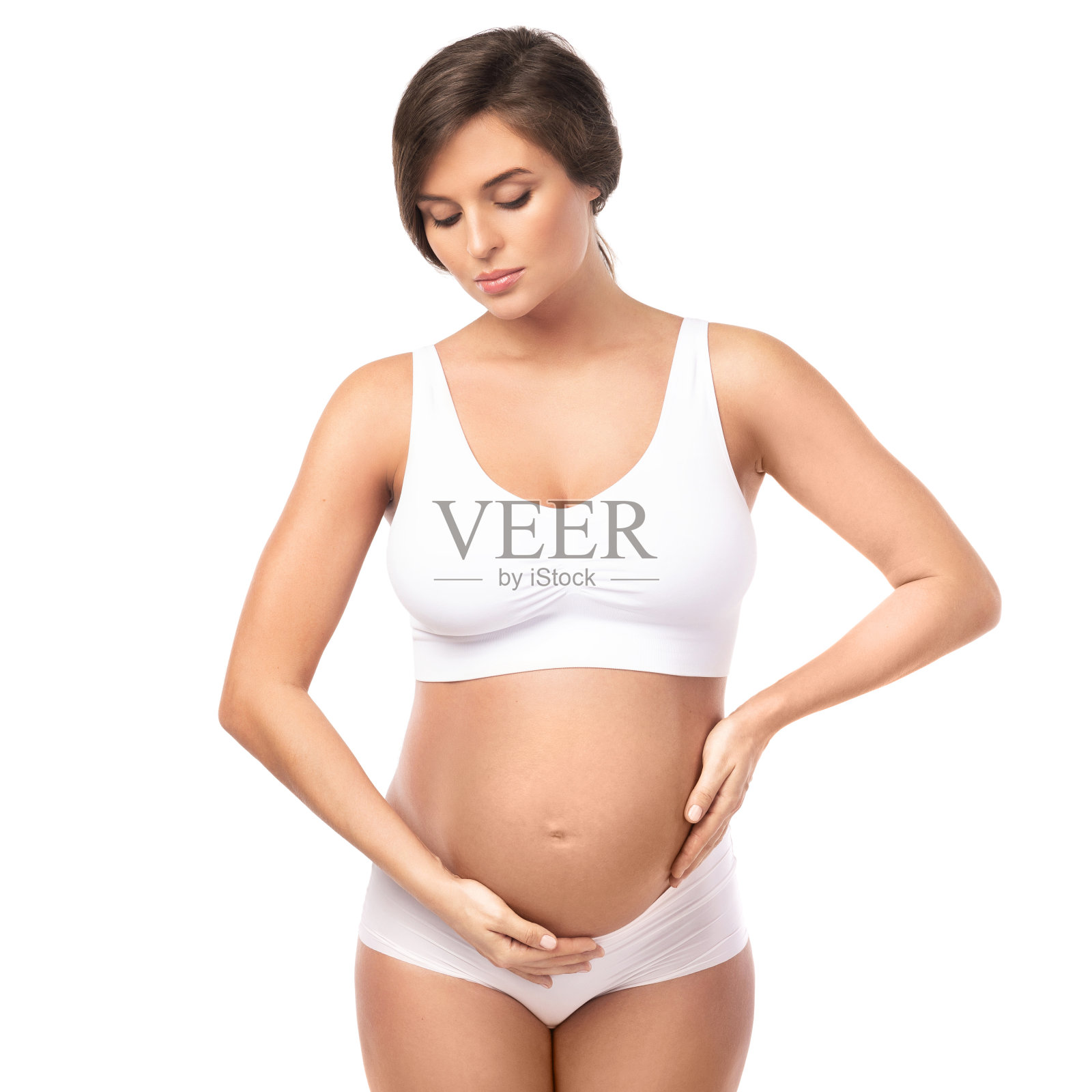 年轻美丽的孕妇在白色背景下照片摄影图片