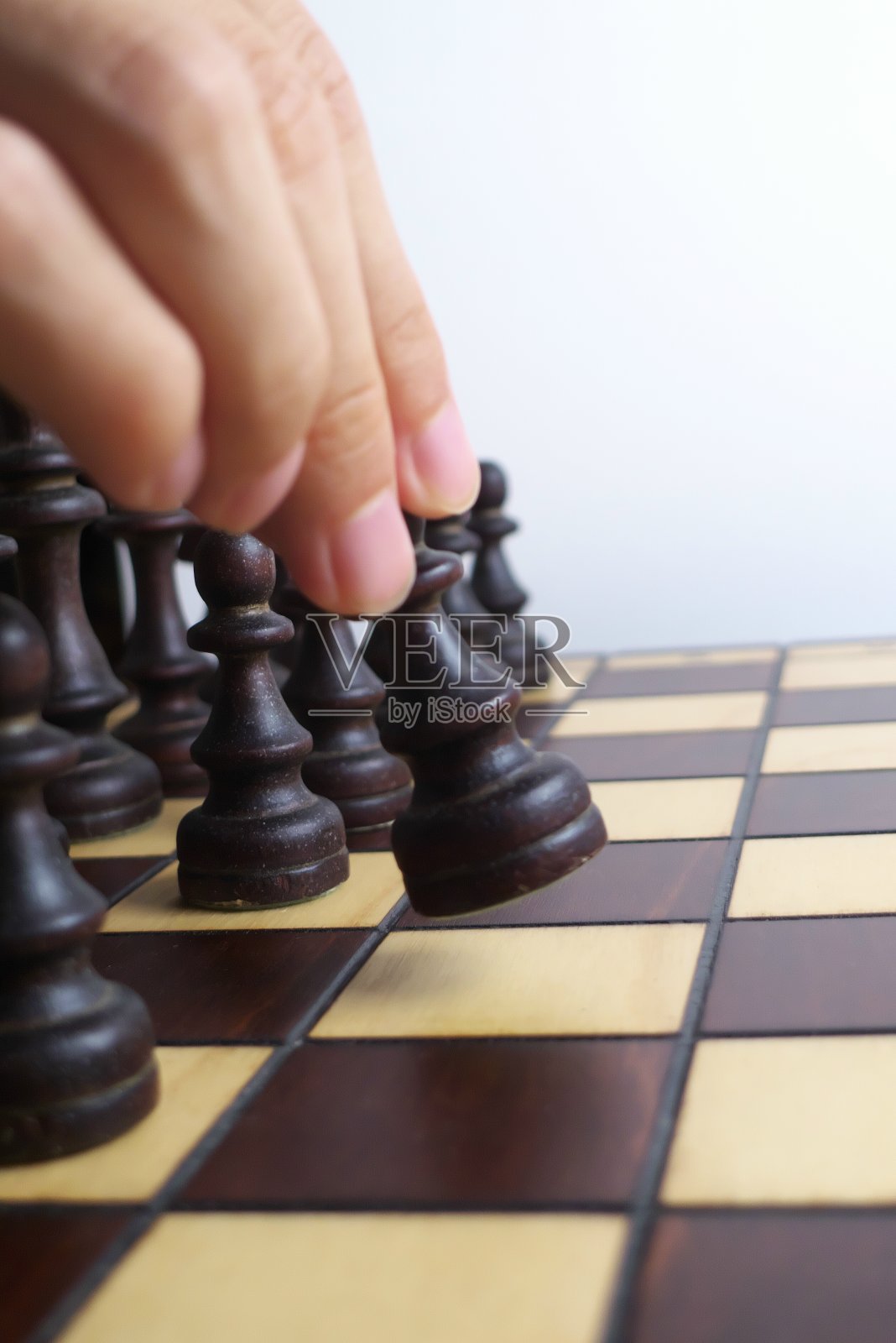 手和木制棋盘，孤立在白色背景照片摄影图片