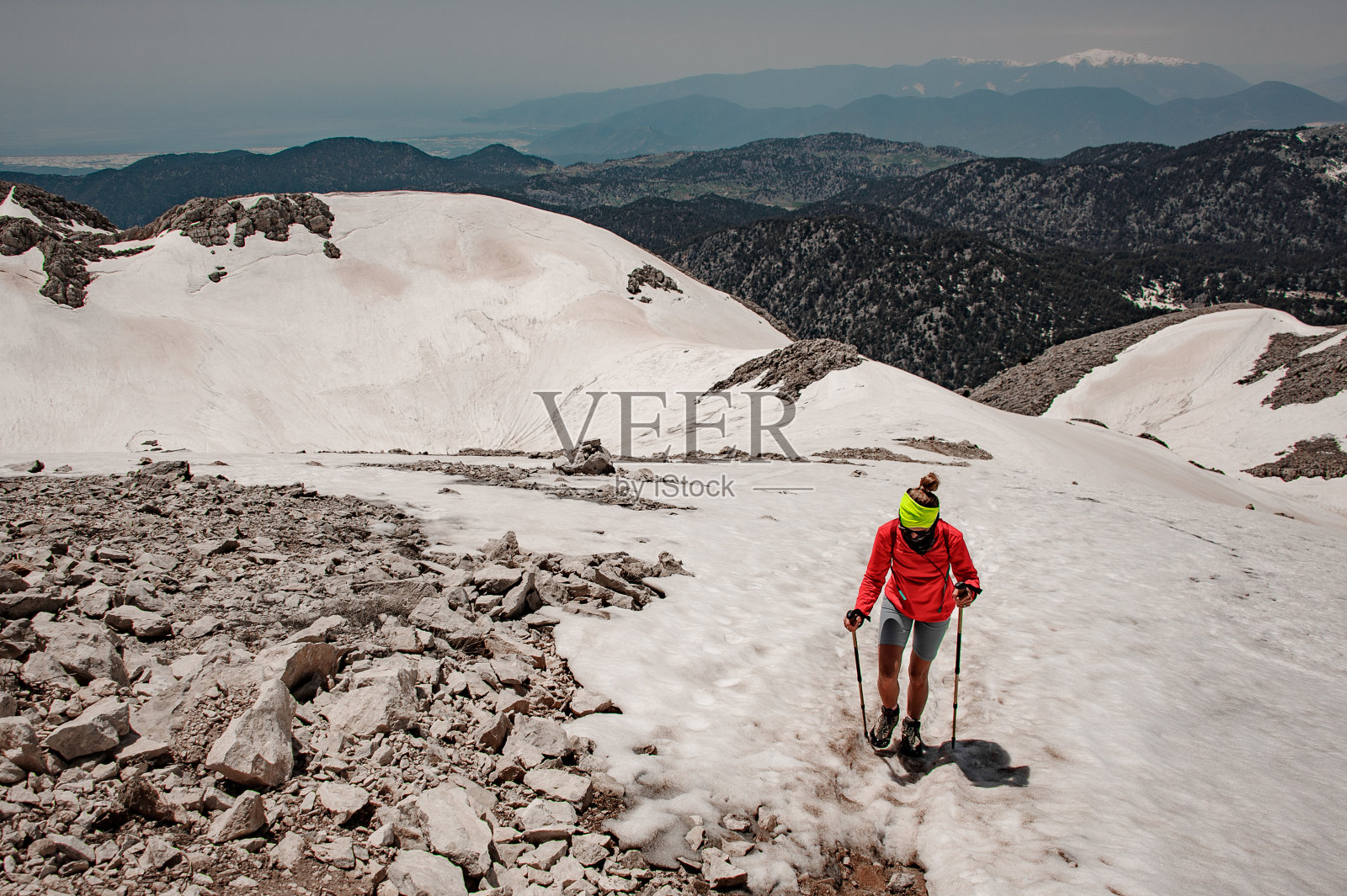 在高地手持手杖的女性徒步旅行者照片摄影图片