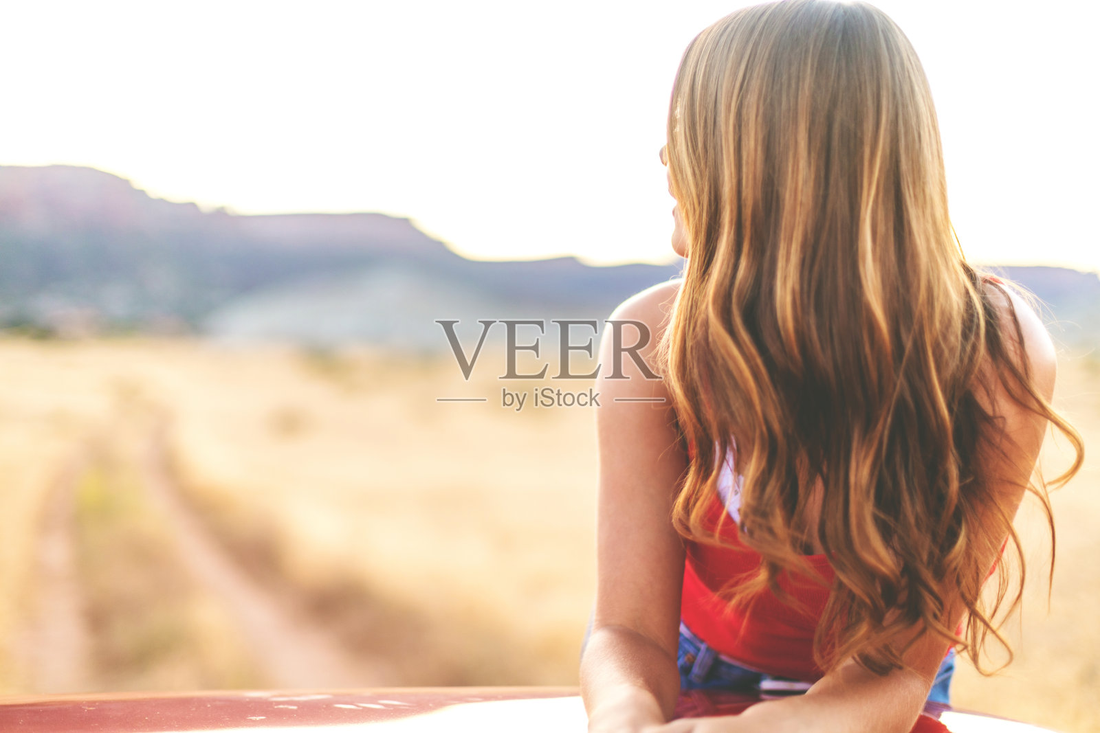 Z一代年轻美丽的女性在非城市沙漠设置在西部科罗拉多的泥土路黄金时间照片摄影图片