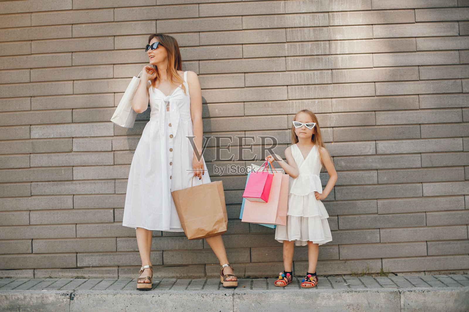 妈妈和女儿拿着购物袋在城市里照片摄影图片